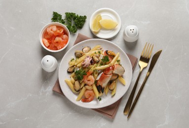 Delicious pasta with sea food served on light grey table, flat lay