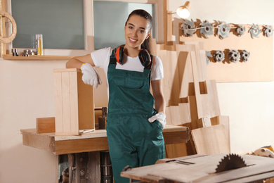 Photo of Professional female carpenter in uniform near workbench