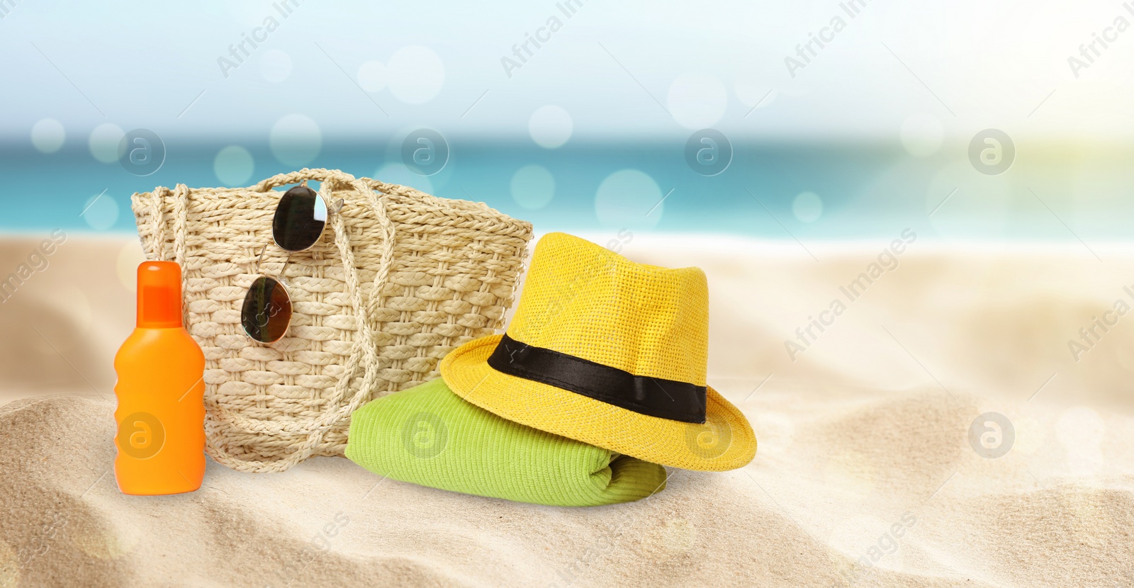 Image of Stylish bag with different accessories on tropical sandy beach, banner design