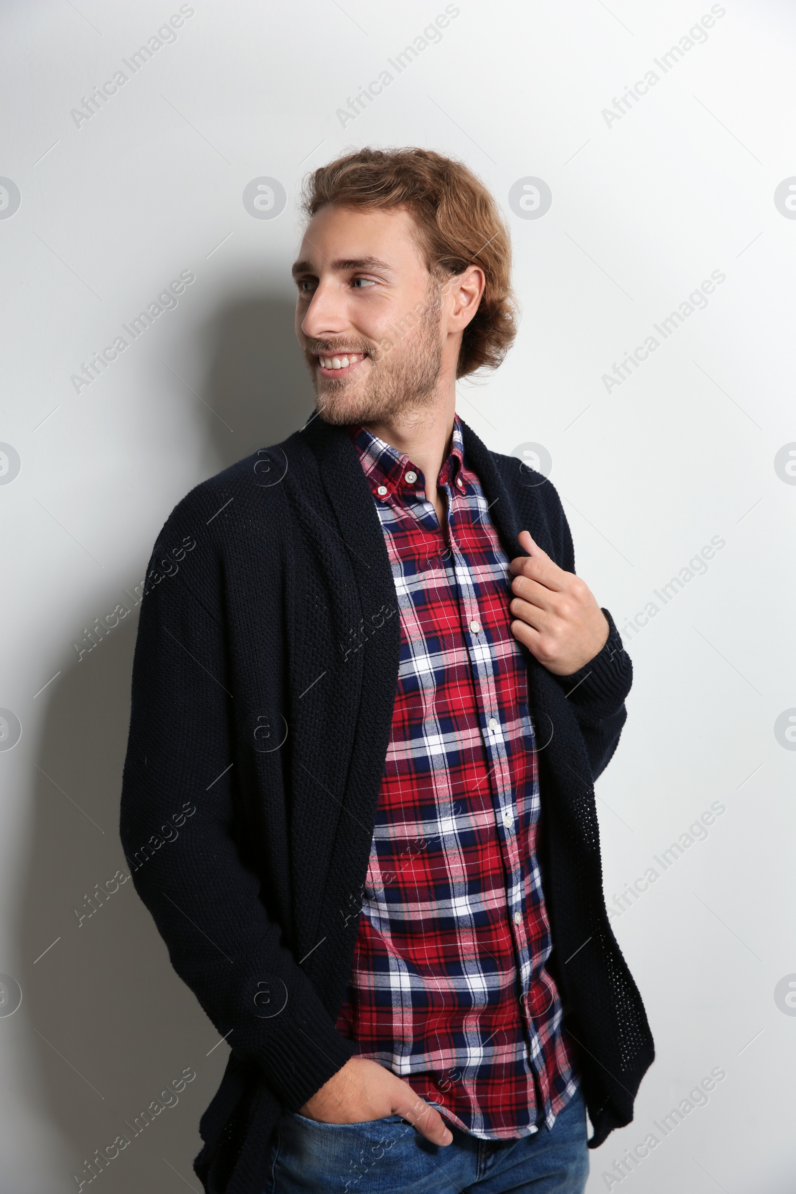 Photo of Handsome young man in shirt and warm sweater on white background