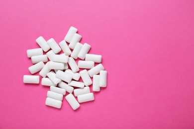 Photo of Tasty white chewing gums on pink background, flat lay. Space for text