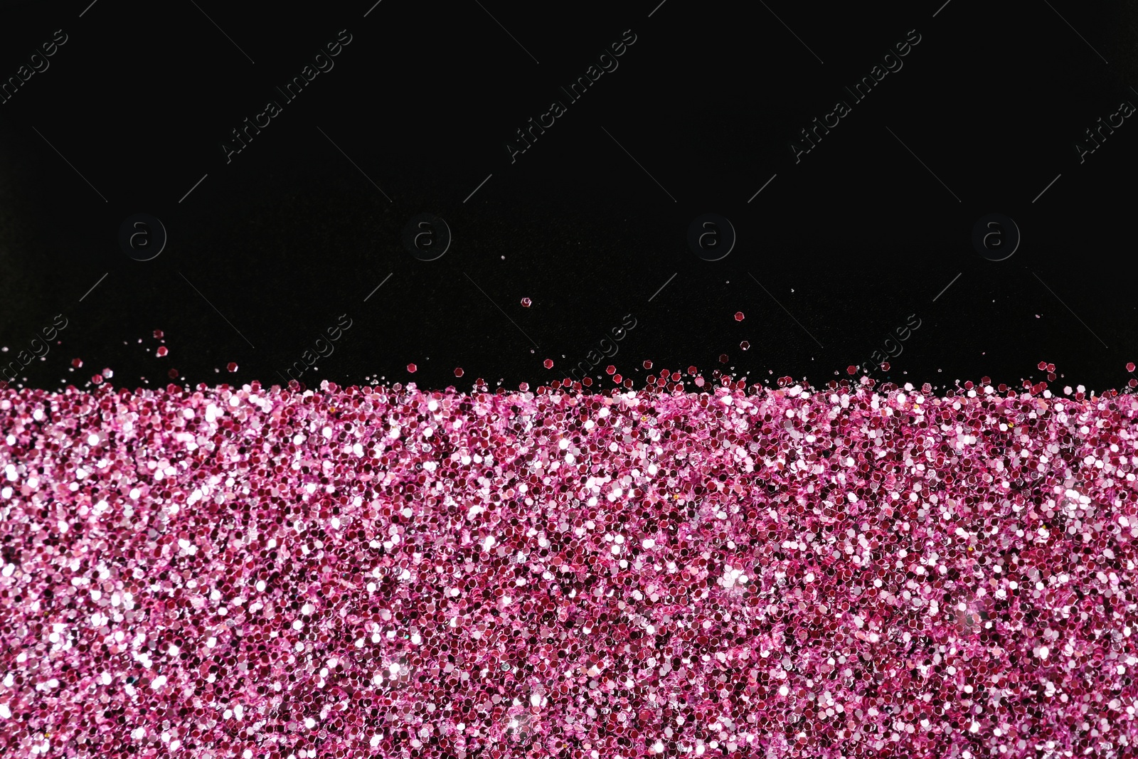 Photo of Rose gold glitter on black background, top view with space for text