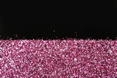 Photo of Rose gold glitter on black background, top view with space for text