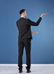 Young business trainer against color wall