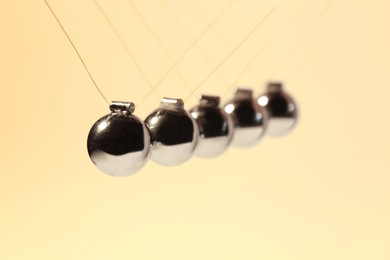 Photo of Newton's cradle on color background, closeup. Physics law of energy conservation