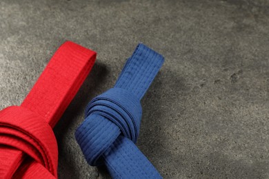 Photo of Colorful karate belts on gray background, closeup. Space for text