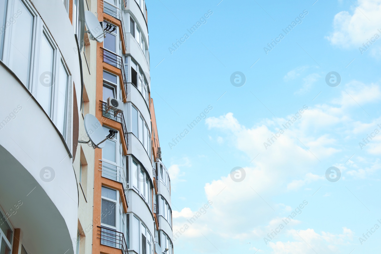 Photo of Exterior of multi-storey apartment building on cloudy day, low angle view. Space for text