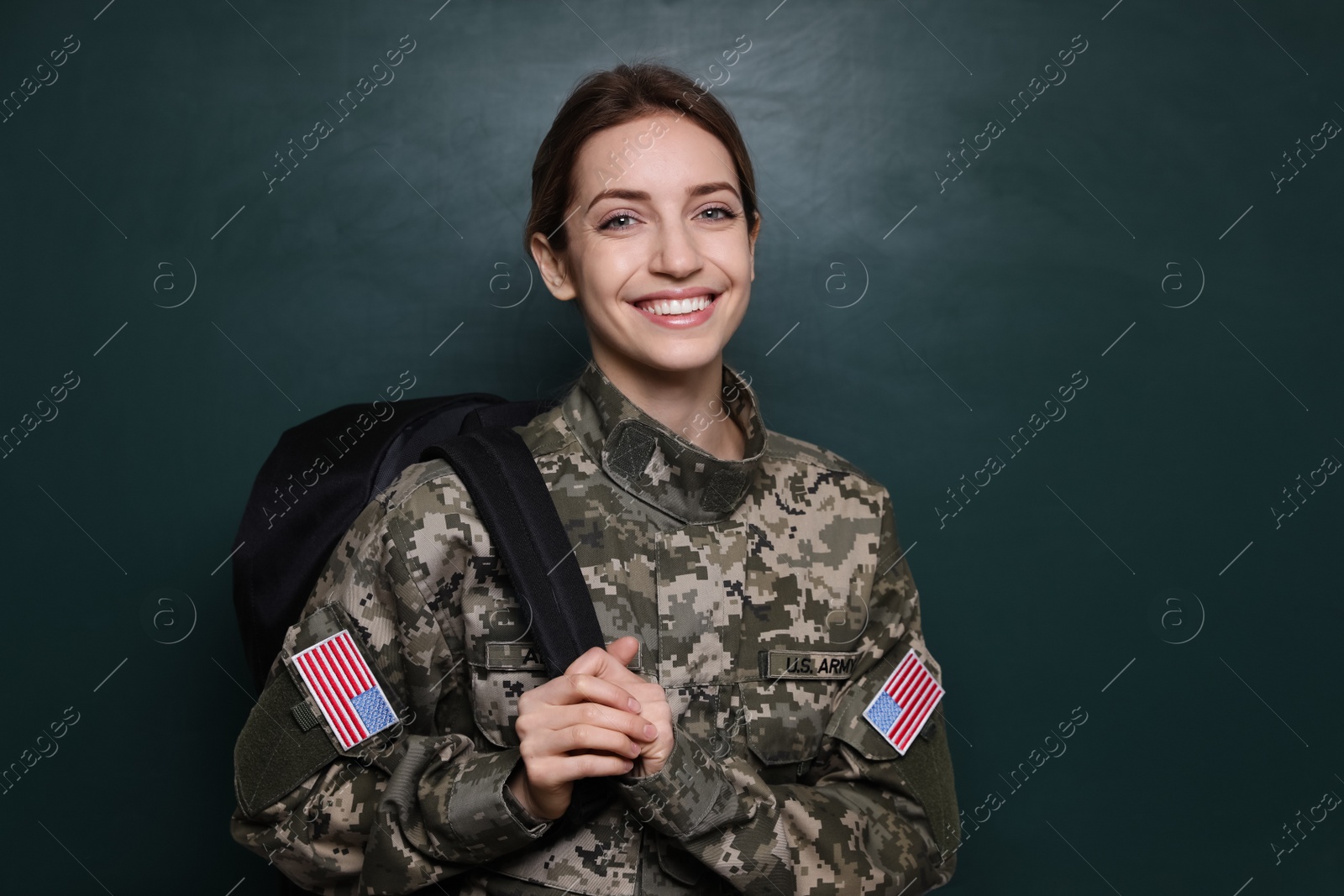 Photo of Female cadet with backpack near chalkboard. Military education