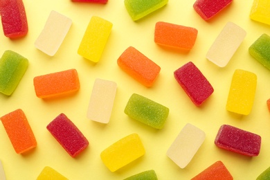 Tasty bright jelly candies on color background, flat lay