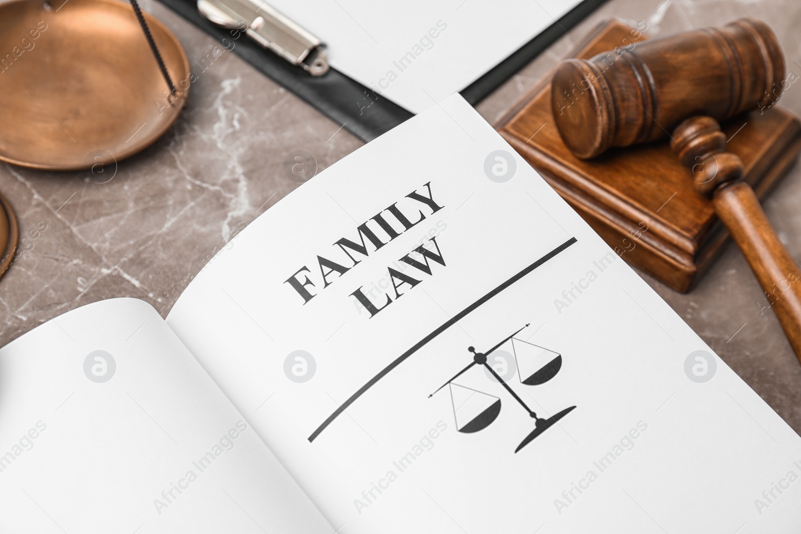 Photo of Open book with words FAMILY LAW and gavel on table, closeup