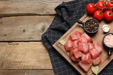 Photo of Raw beef meat and different ingredients for cooking delicious goulash on wooden table, flat lay. Space for text