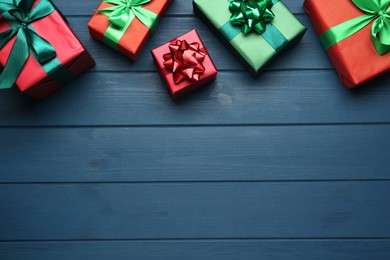 Photo of Many gift boxes on blue wooden table, flat lay. Space for text