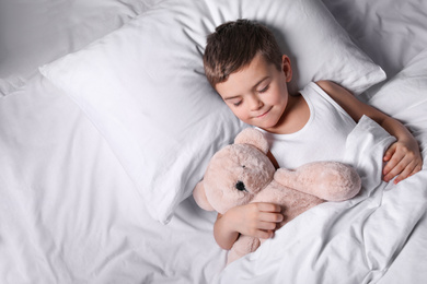 Photo of Little boy sleeping with teddy bear at home. Bedtime