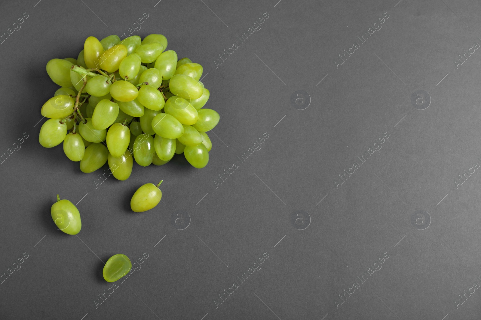 Photo of Fresh ripe juicy grapes on grey background, top view. Space for text