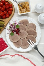 Photo of Tasty beef tongue pieces, berries, red onion and ingredients on white wooden table, flat lay