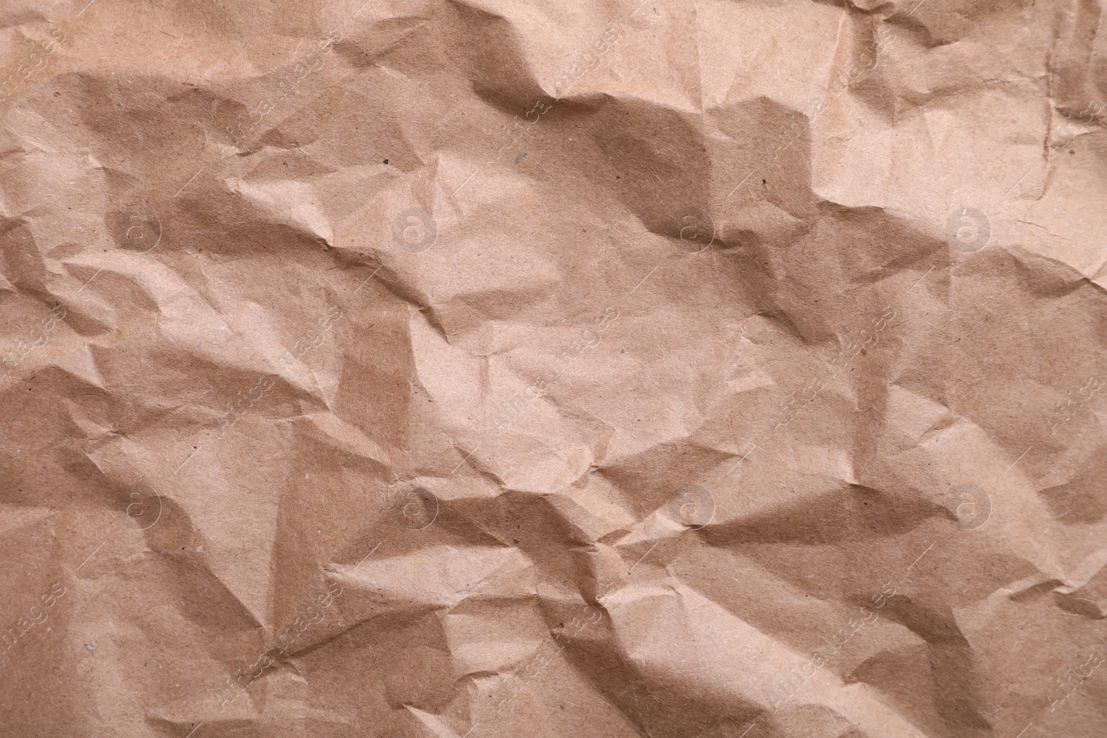 Photo of Texture of wrinkled kraft paper bag as background, closeup