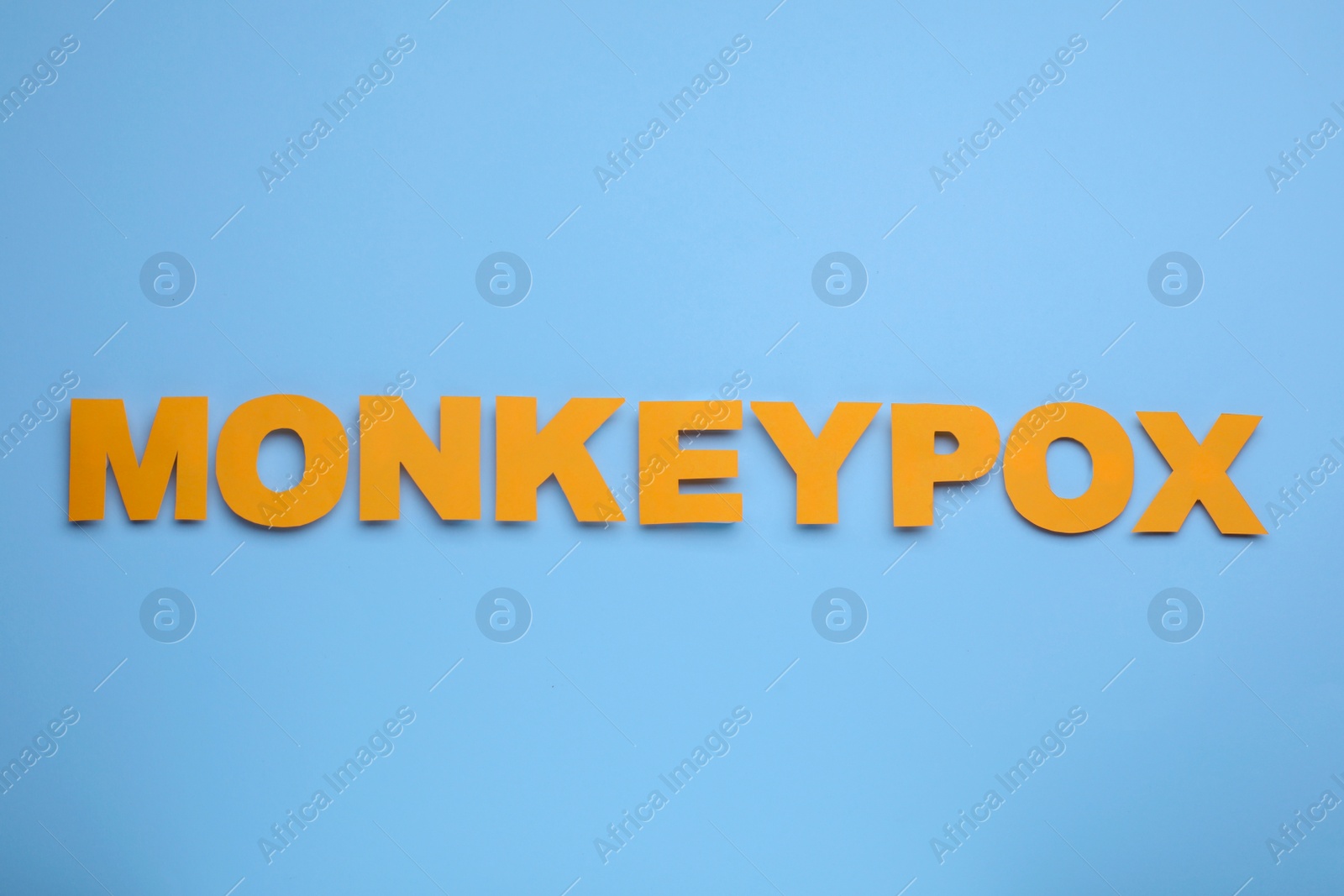 Photo of Word Monkeypox made of paper letters on light blue background, top view