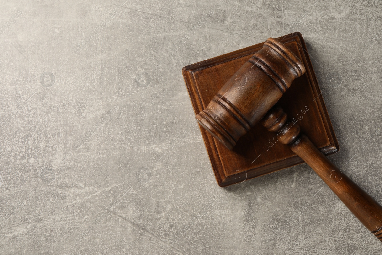 Photo of Wooden gavel on grey textured table, top view. Space for text