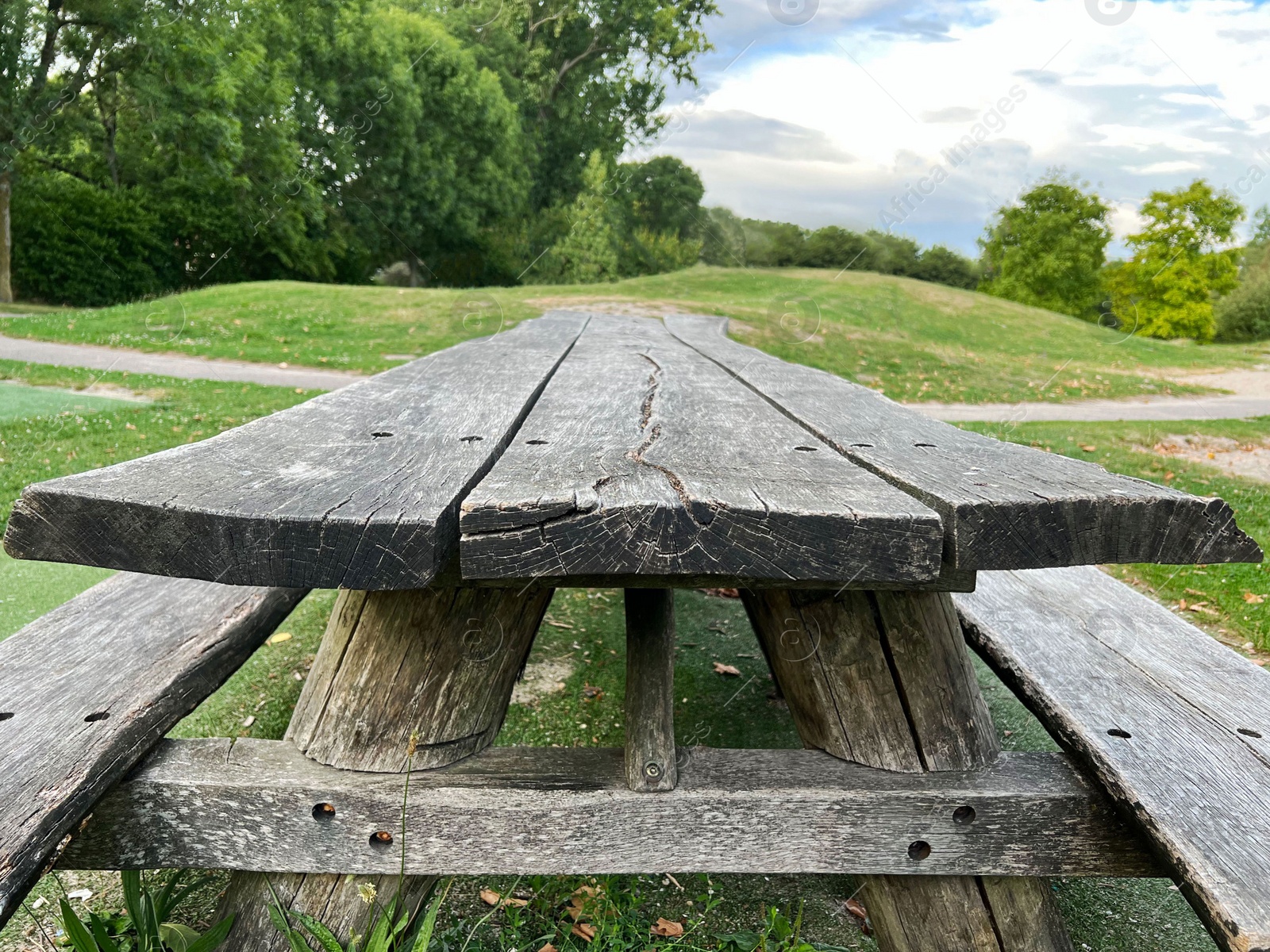 Photo of Empty wooden picnic table with benches outdoors