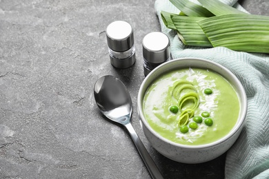 Photo of Fresh vegetable detox soup made of green peas served on table. Space for text