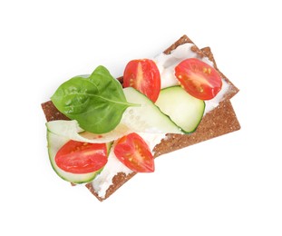 Photo of Tasty rye crispbreads with cream cheese, vegetables and basil isolated on white, top view