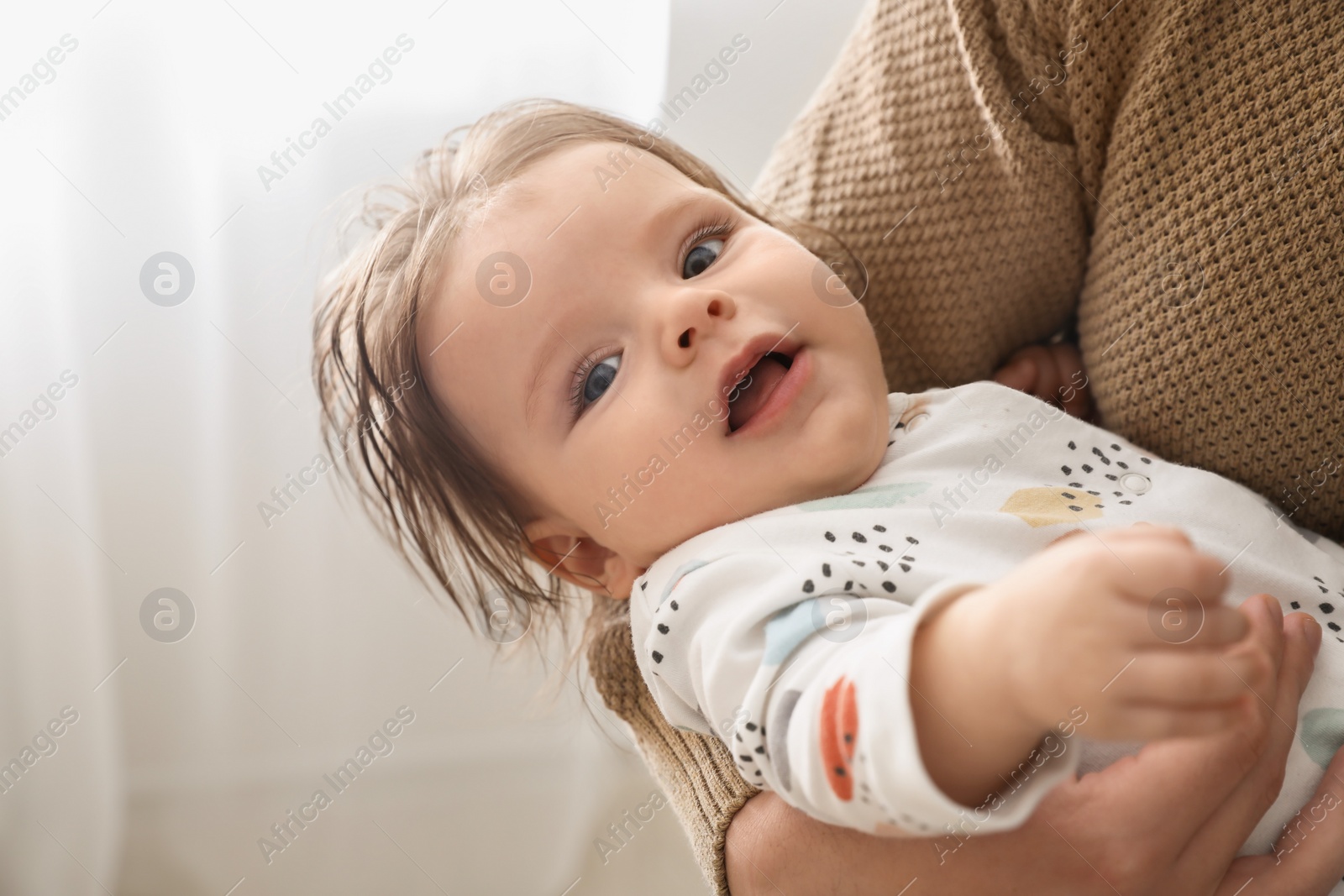 Photo of Father holding his daughter indoors, closeup view