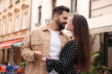 Lovely couple dancing together on city street