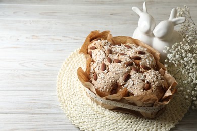 Photo of Delicious Italian Easter dove cake (traditional Colomba di Pasqua) and festive decor on white wooden table, space for text