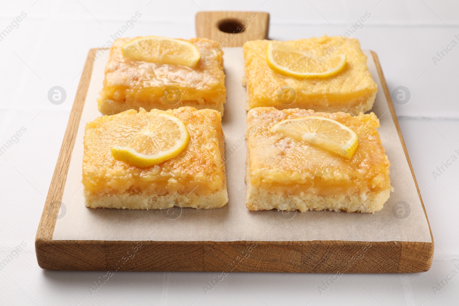 Photo of Tasty lemon bars on white table, closeup