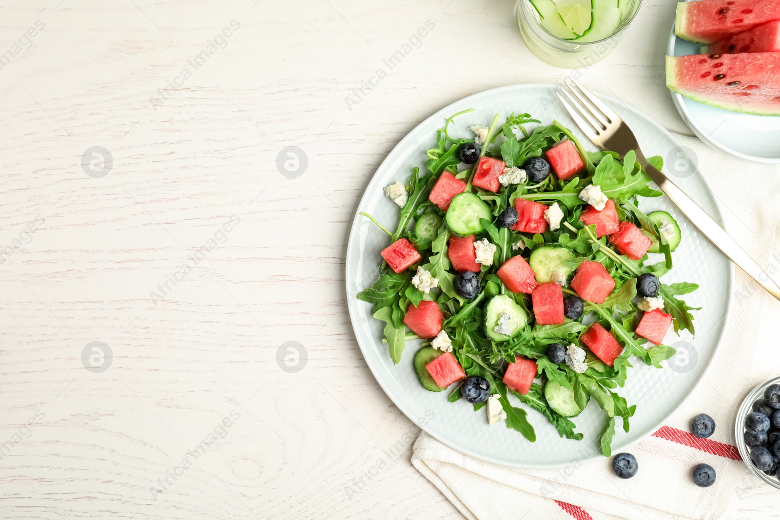 Photo of Delicious salad with watermelon served on white table, flat lay. Space for text