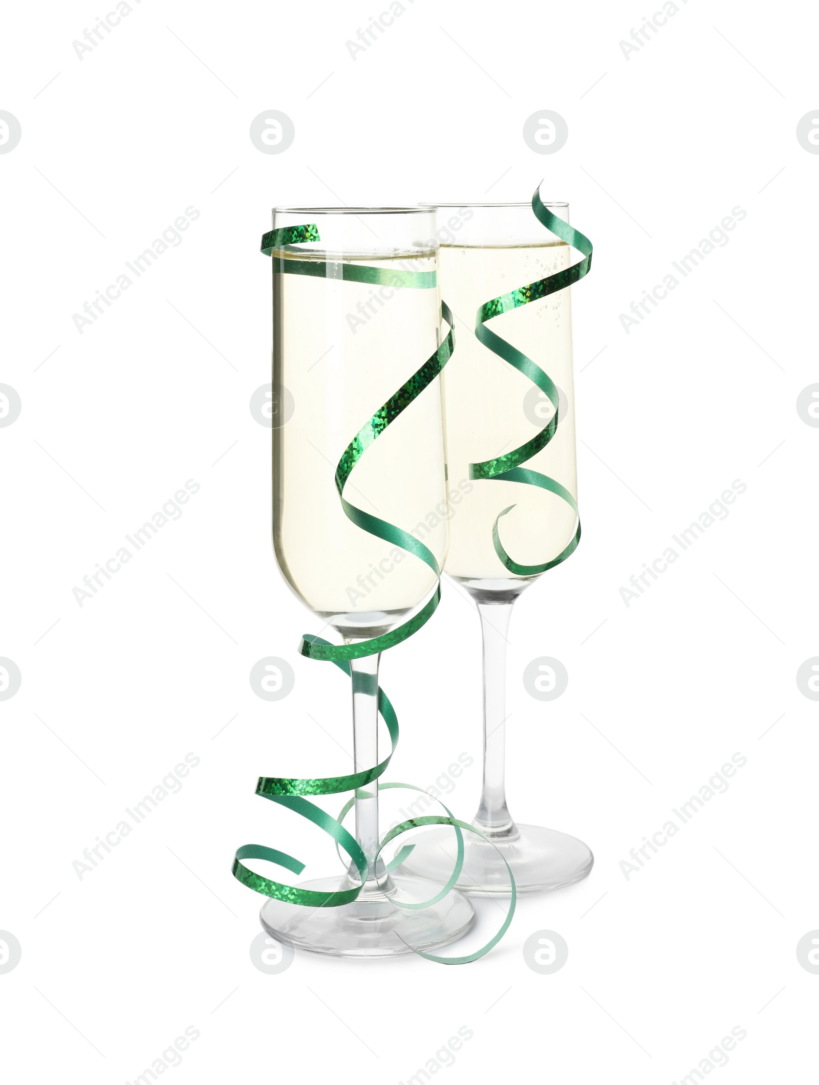 Photo of Glasses of champagne and serpentine streamers on white background