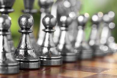 Photo of Silver pawns on chess board, closeup. Space for text