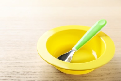 Set of plastic dishware on wooden table. Serving baby food