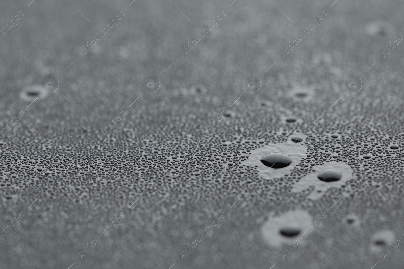 Photo of Water drops on grey surface, closeup view