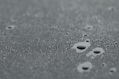 Photo of Water drops on grey surface, closeup view