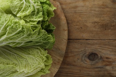 Photo of Fresh ripe leavesChinese cabbage on wooden table, top view. Space for text