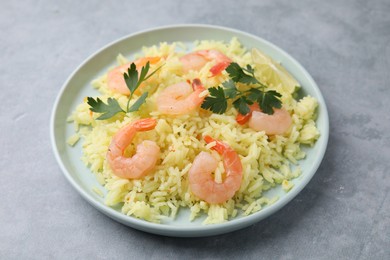 Delicious risotto with shrimps, lime and parsley on light grey table