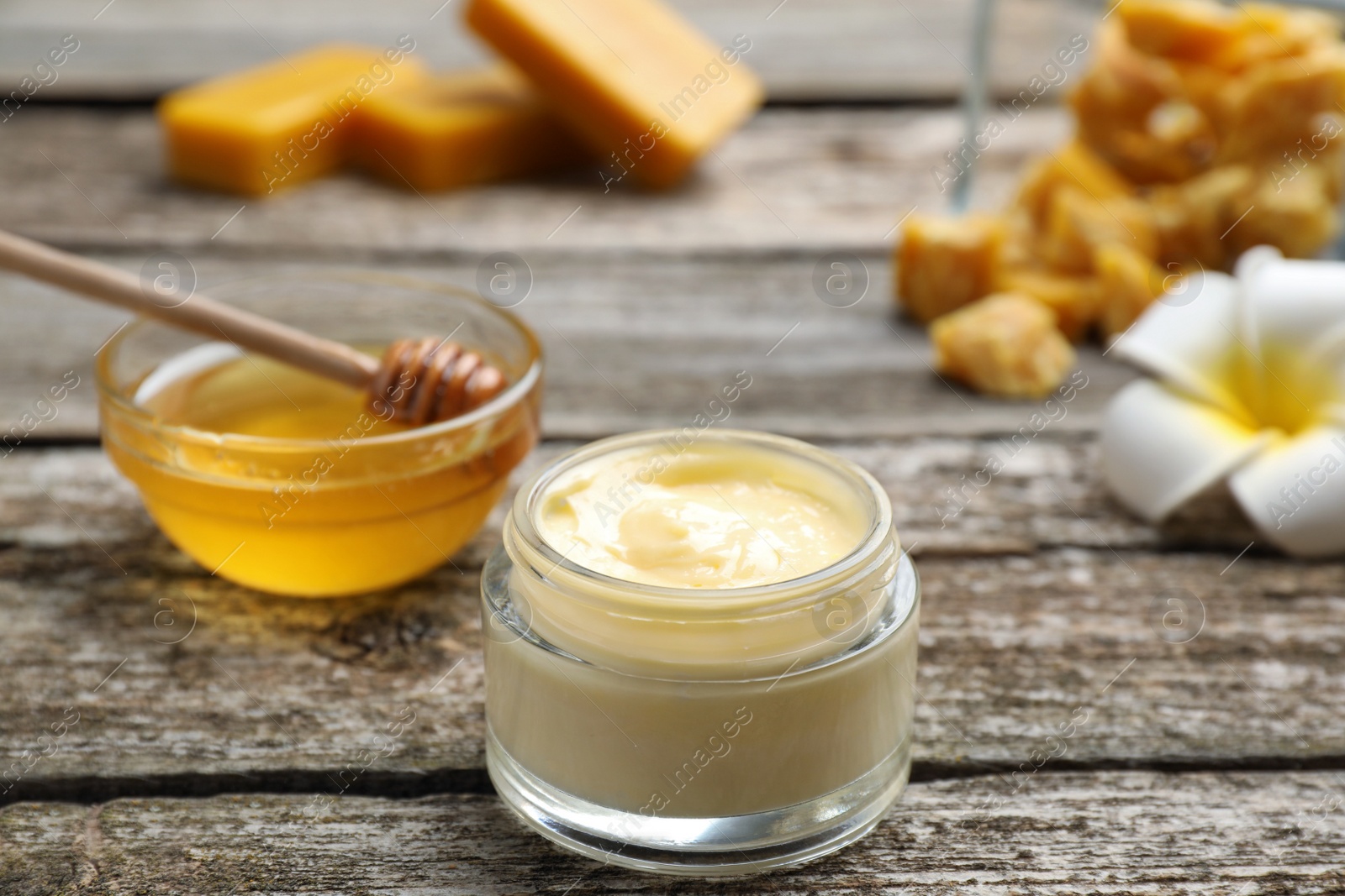 Photo of Cream with natural beeswax component on wooden table, closeup