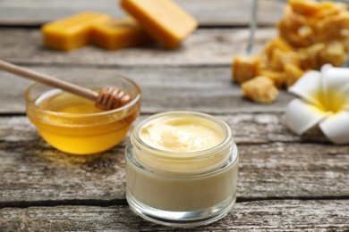 Photo of Cream with natural beeswax component on wooden table, closeup