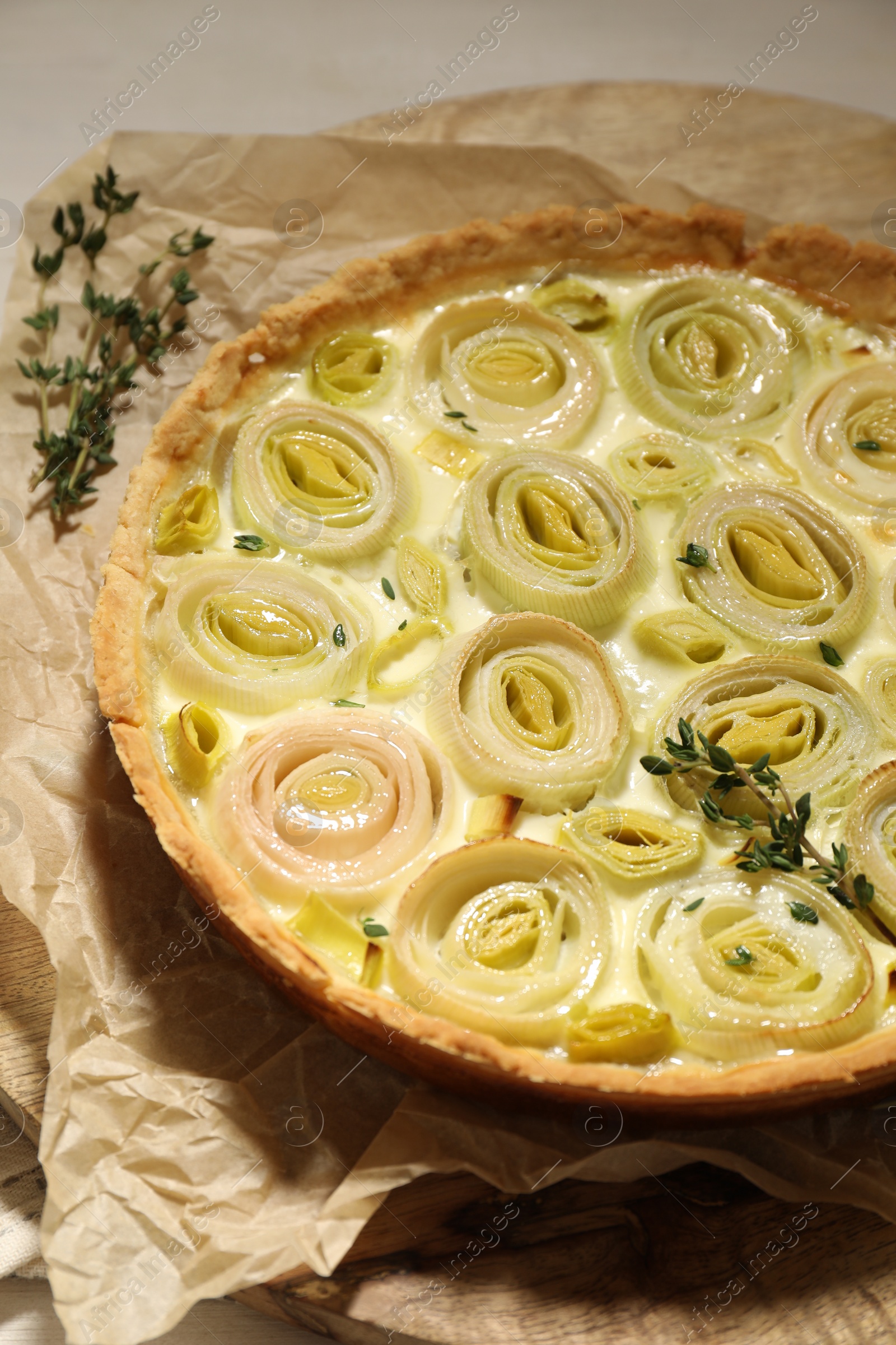 Photo of Tasty leek pie with thyme on light table, closeup