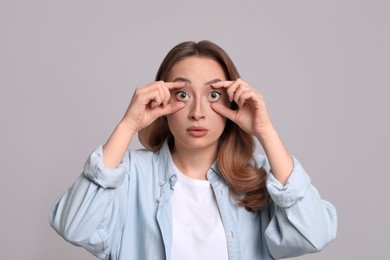 Woman with yellow eyes on grey background. Liver problems symptom