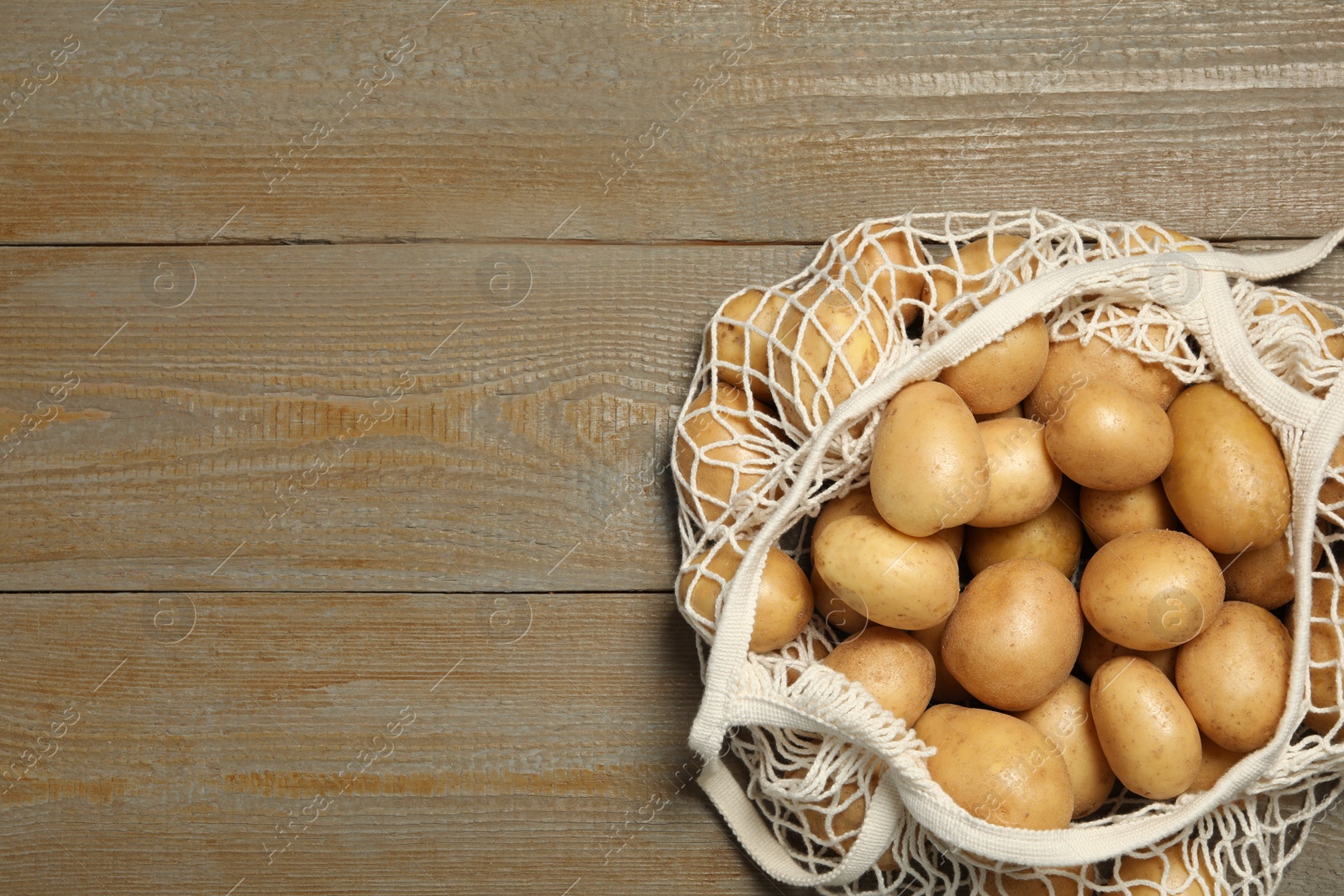 Photo of Raw fresh organic potatoes on wooden background, top view. Space for text