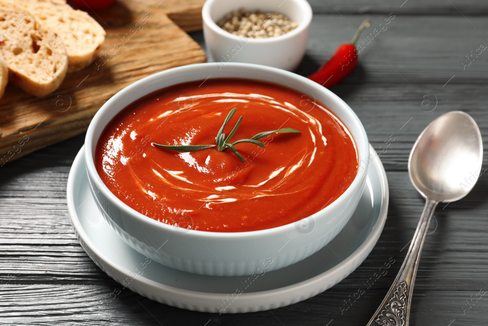 Photo of Bowl with fresh homemade tomato soup on wooden table