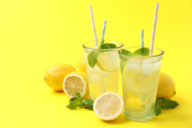 Freshly made natural lemonade on yellow background. Summer refreshing drink
