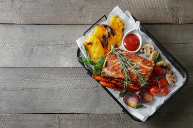 Photo of Delicious grilled meat and vegetables served with sauce on wooden table, top view. Space for text