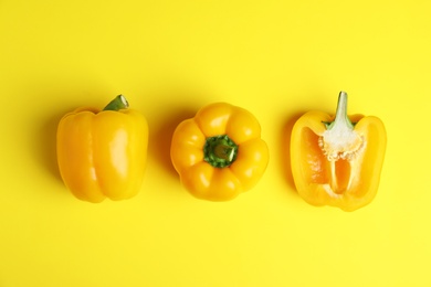 Ripe bell peppers on yellow background, flat lay