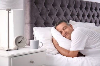 Man sleeping on comfortable pillow in bed at home