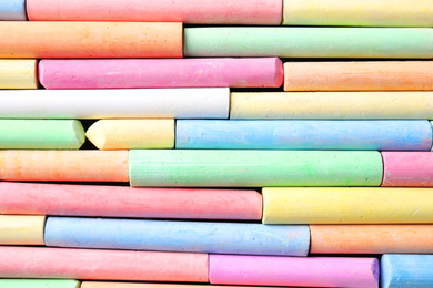 Many pieces of color chalk as background, top view