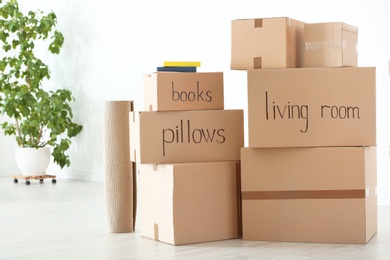 Photo of Cardboard boxes and household stuff indoors. Moving day