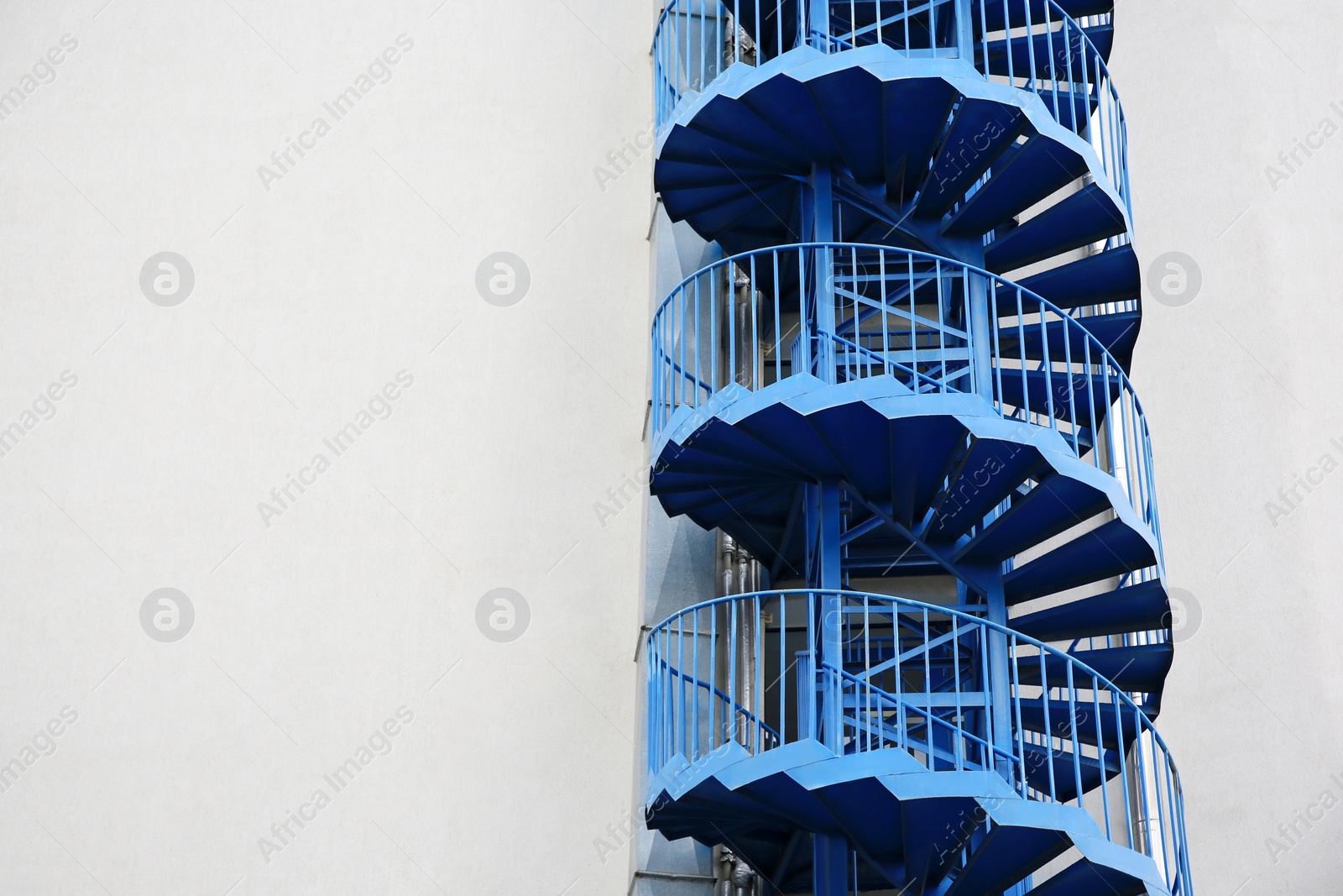 Photo of View of modern metal empty fire escape ladder near building outdoors. Space for text
